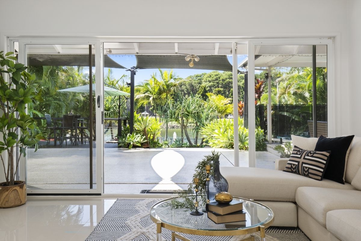 A living room with a couch , coffee table , and sliding glass doors leading to a patio.