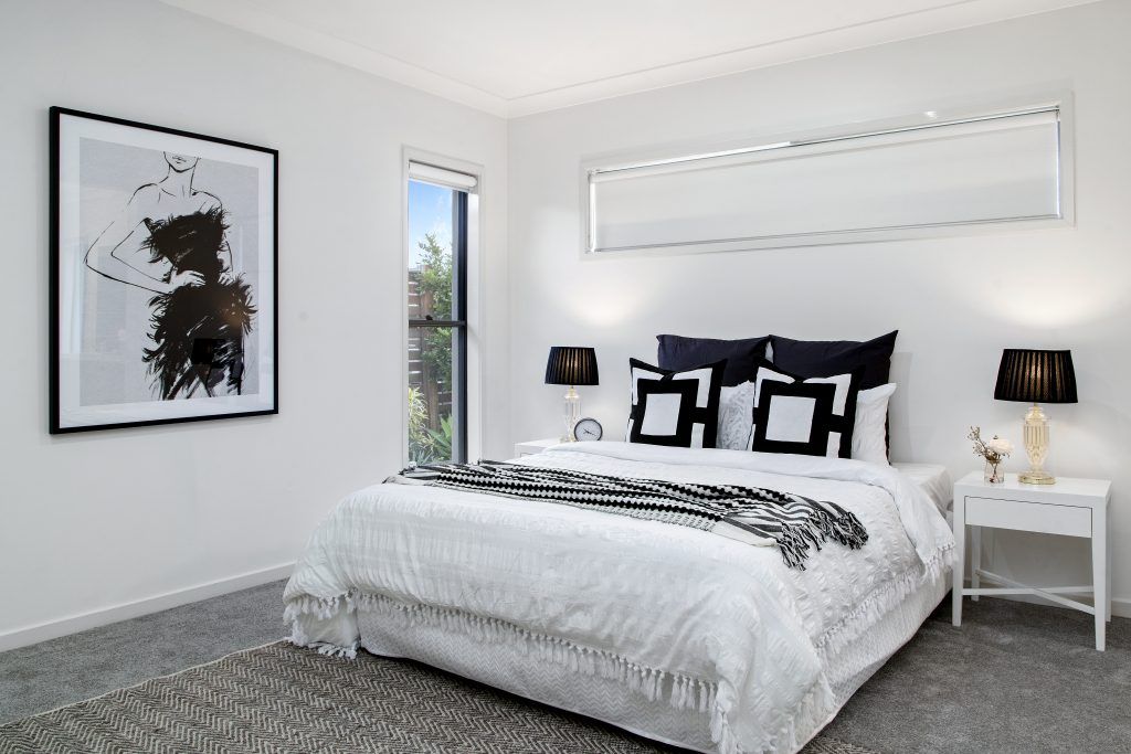 A bedroom with a large bed and two lamps