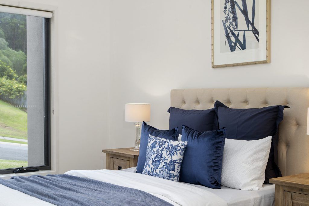 A bedroom with a bed , nightstands , lamps and a window.