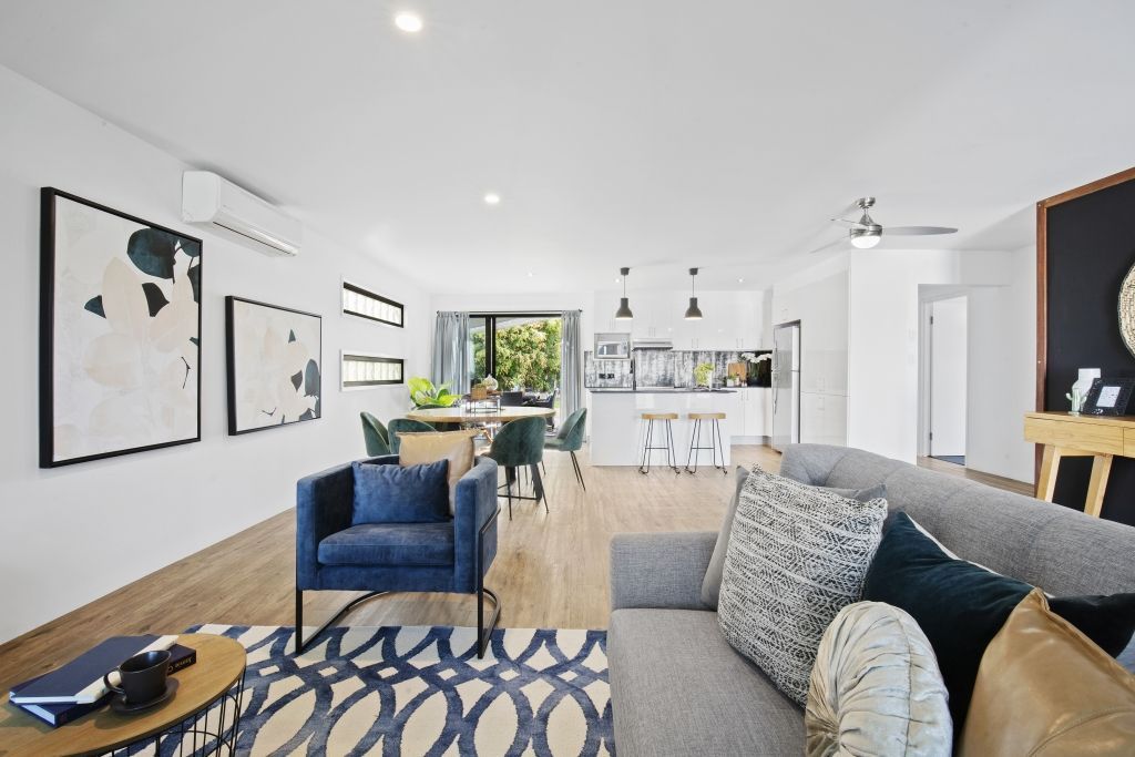 A living room with a couch , chair , table and rug.