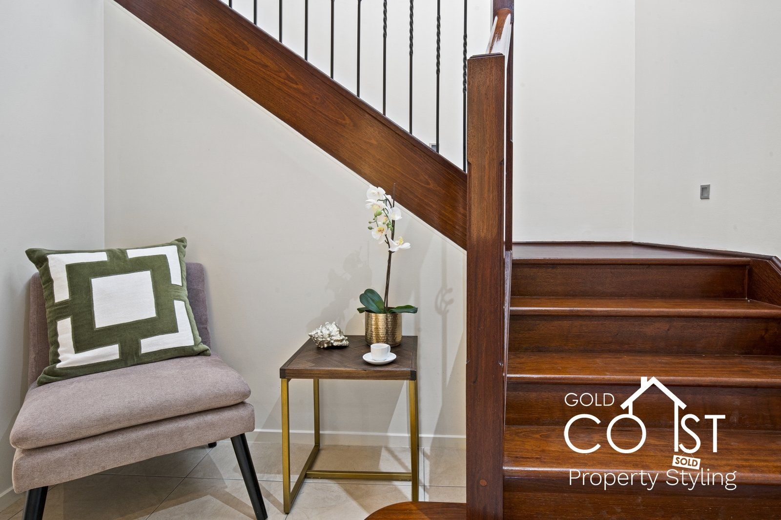 There is a chair and a table under the stairs.