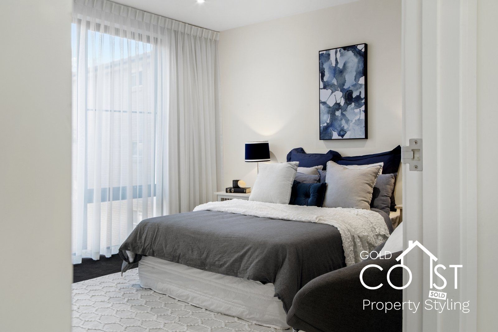 A bedroom with a large bed and a large window.