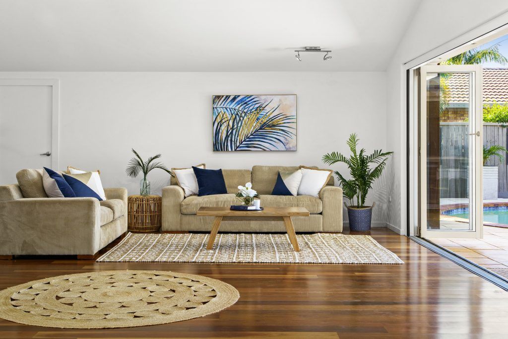 A living room with two couches , a coffee table , and a rug.