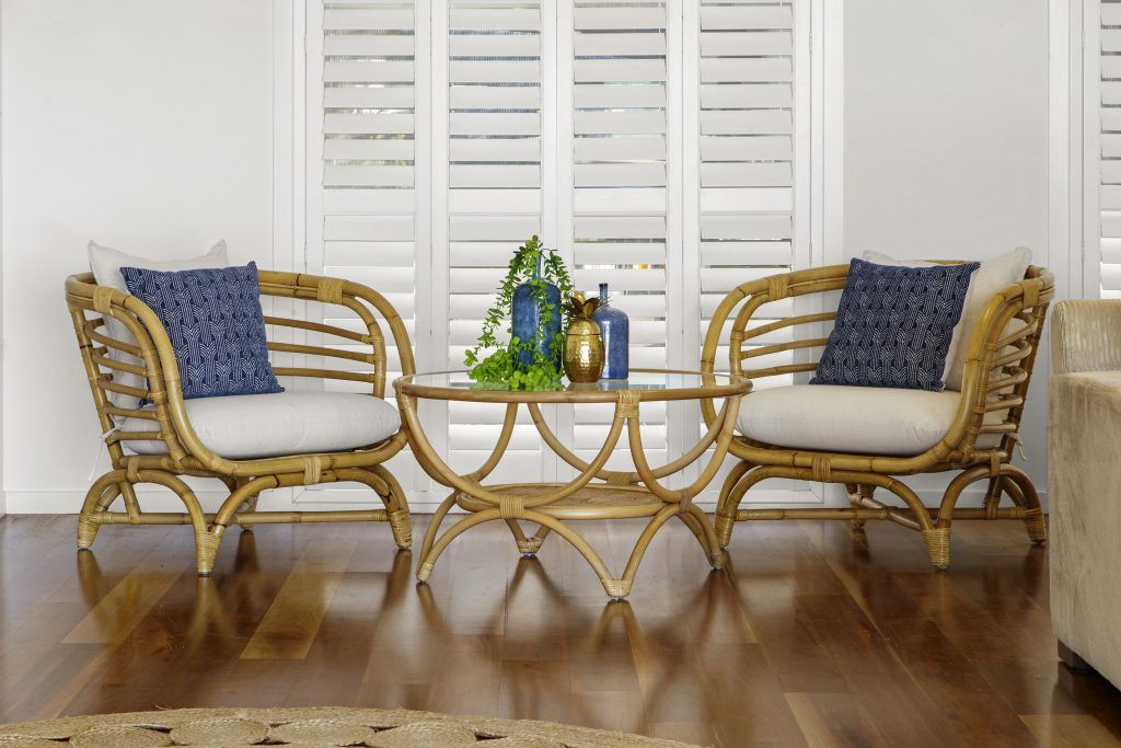 A living room with two wicker chairs and a coffee table.