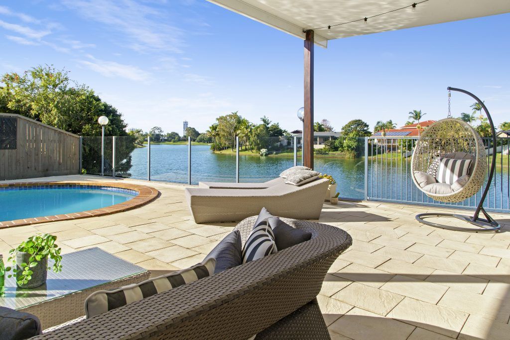There is a swimming pool in the backyard of a house.