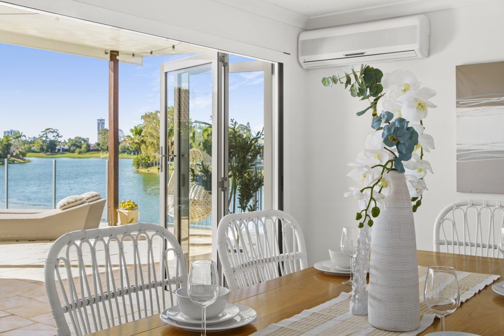 A dining room with a table and chairs and a view of a lake.