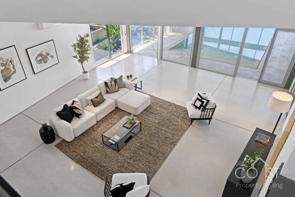 An aerial view of a living room with a couch , chairs , coffee table and rug.