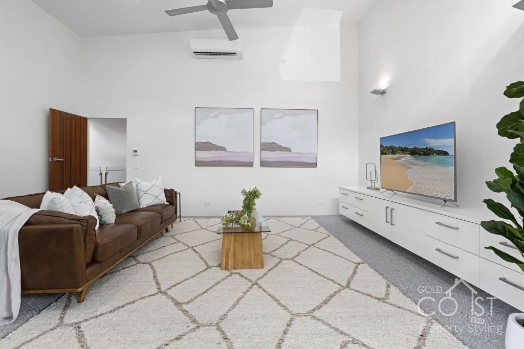A living room with a couch , coffee table , and television.