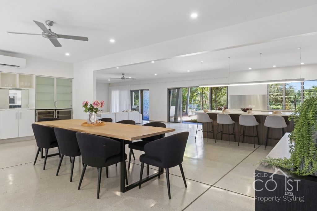 A large dining room with a table and chairs and a ceiling fan.
