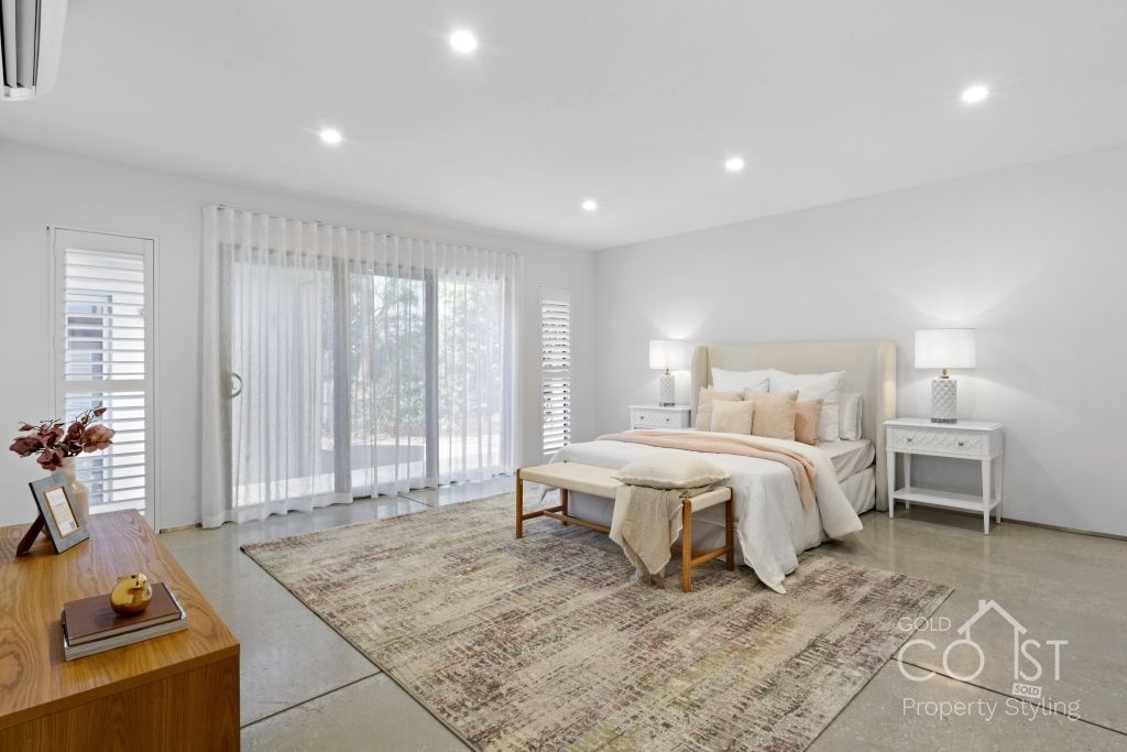 A bedroom with a large bed , sliding glass doors and a rug.