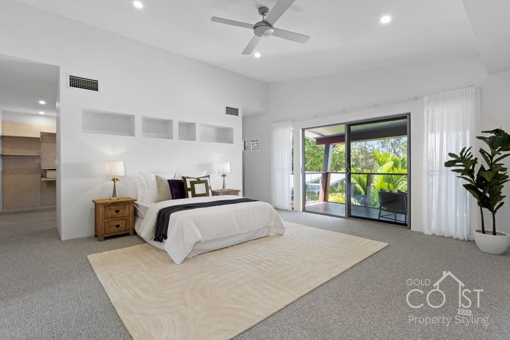 A bedroom with a large bed and a ceiling fan.