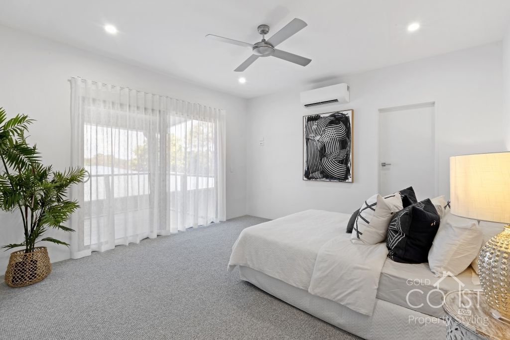 A bedroom with a bed and a ceiling fan.