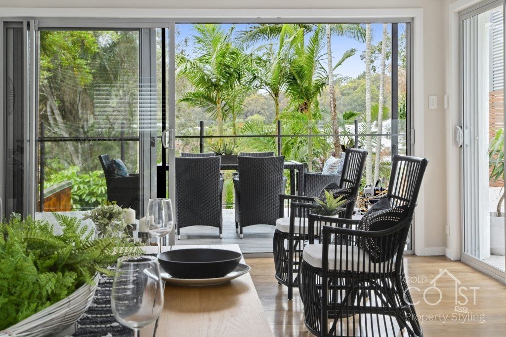A living room with a table and chairs and a sliding glass door leading to a patio.