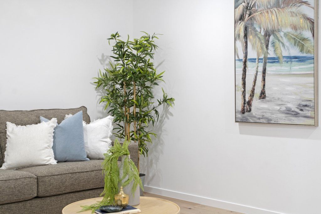 A living room with a couch , table , and painting on the wall.