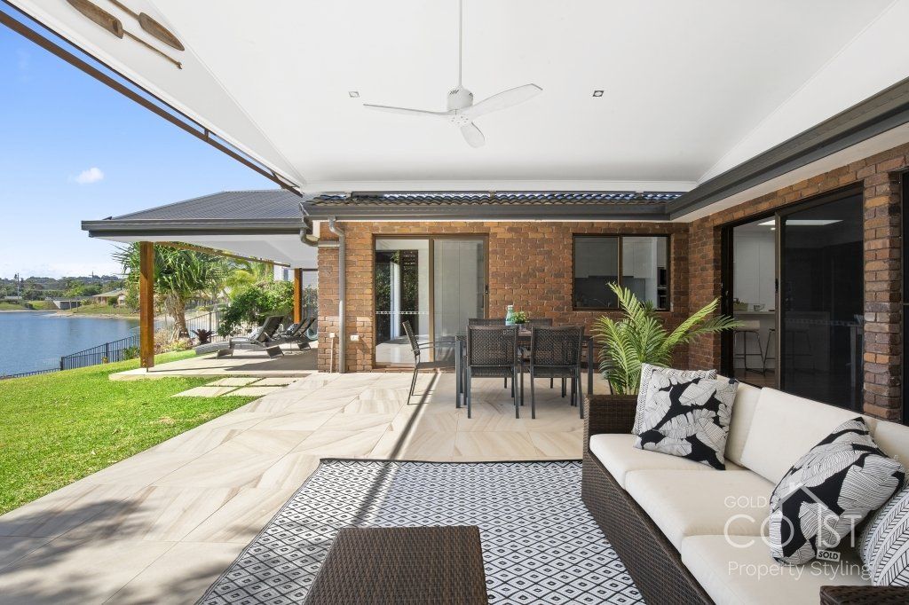 A patio with a couch , table , chairs and a ceiling fan
