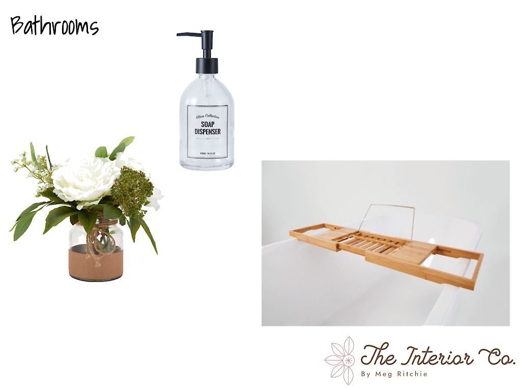 A bathroom with a vase of flowers , a soap dispenser , and a bathtub tray.