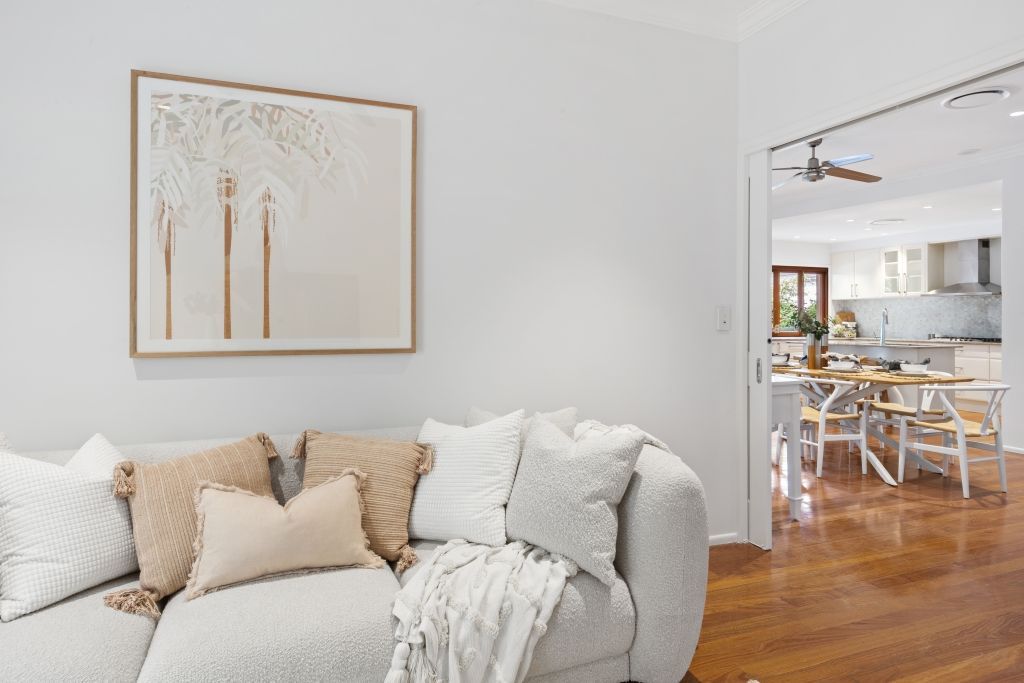 A living room with a couch and a painting on the wall.