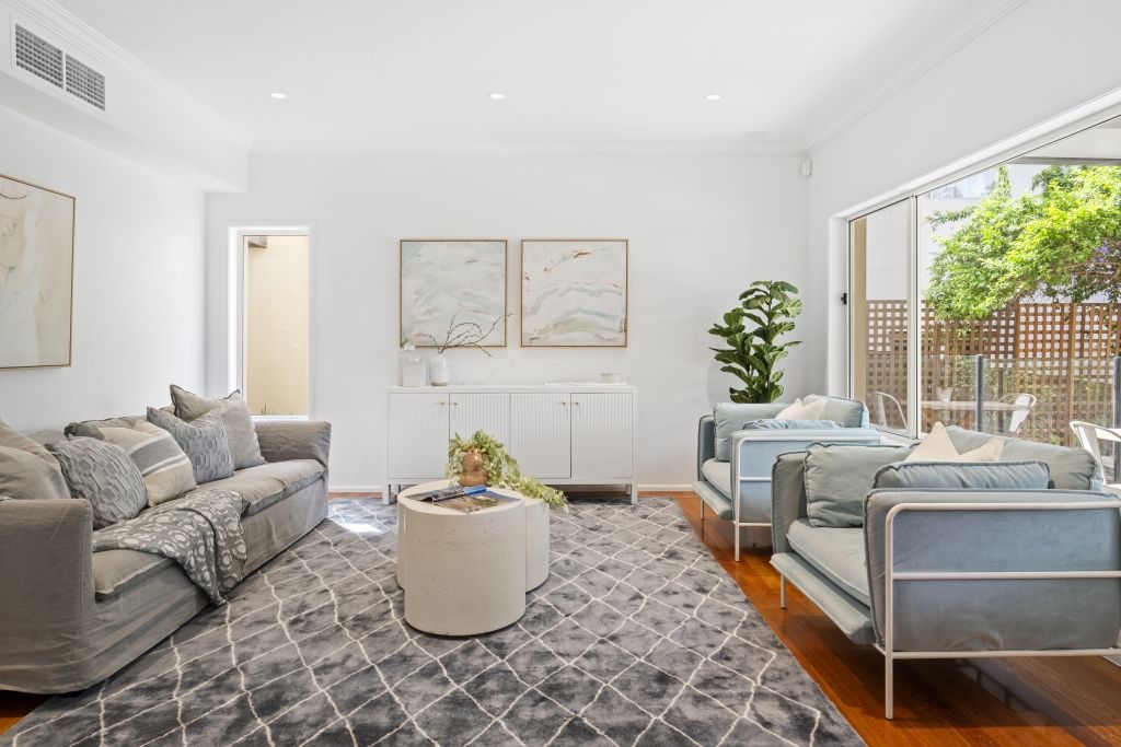 A living room filled with furniture and a rug.
