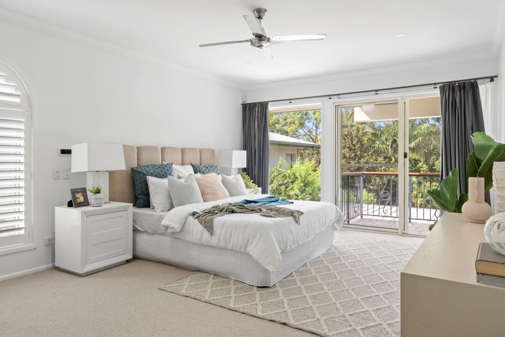A bedroom with a large bed and a ceiling fan.