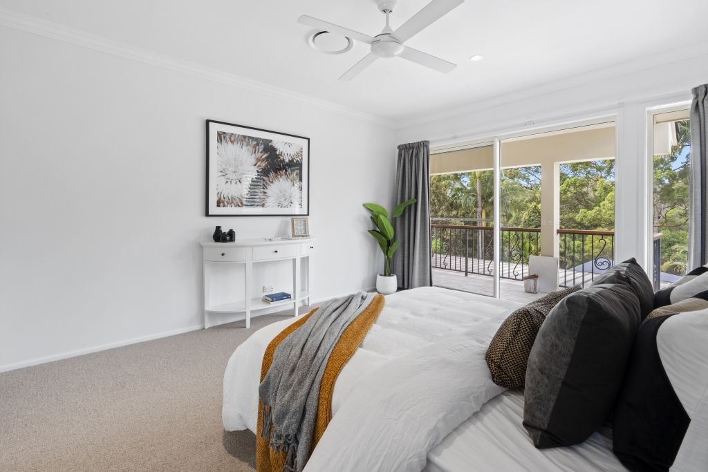A bedroom with a large bed and a ceiling fan.