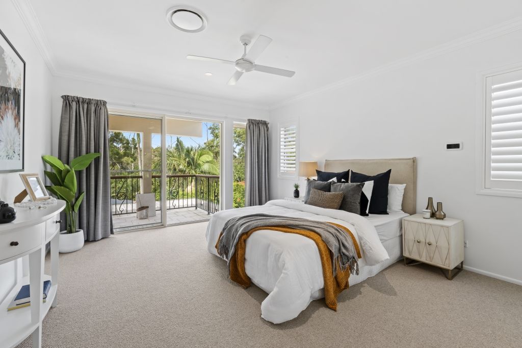 A bedroom with a large bed and a ceiling fan.