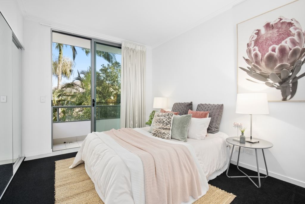 A bedroom with a large bed and a painting on the wall.