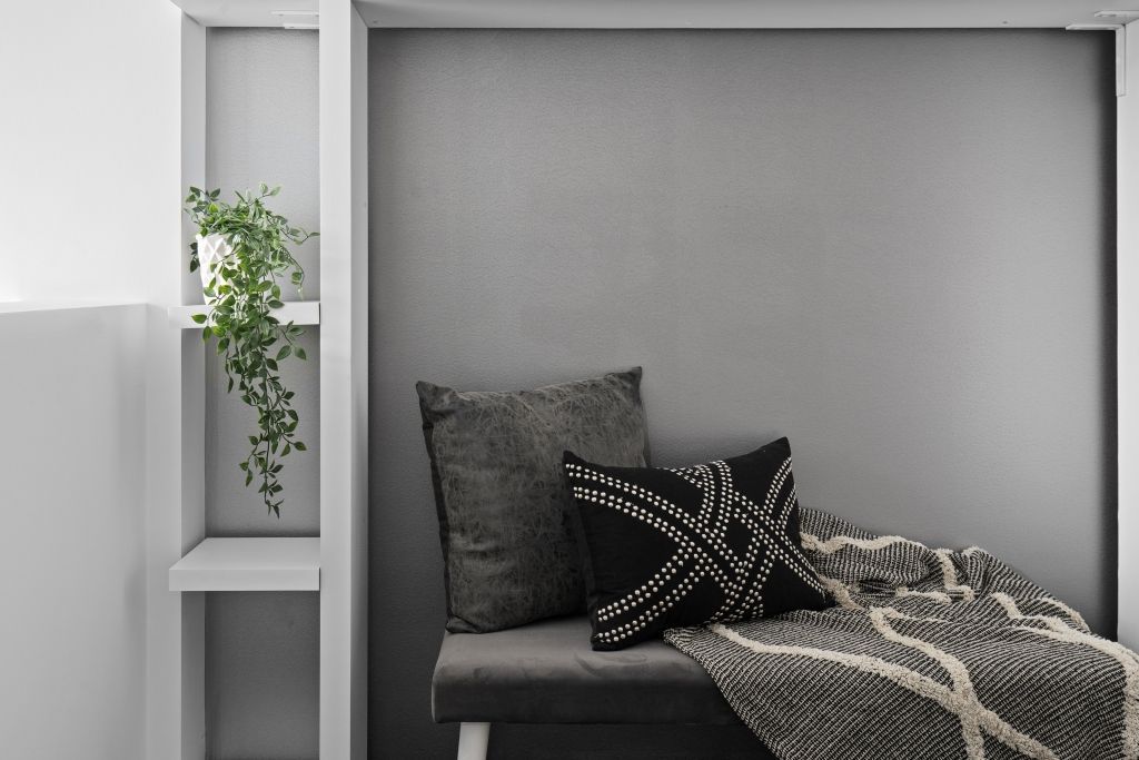 There is a couch with pillows and a blanket on it.