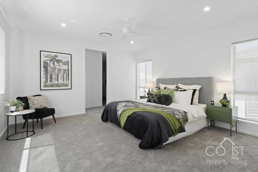 A bedroom with a large bed and a ceiling fan.