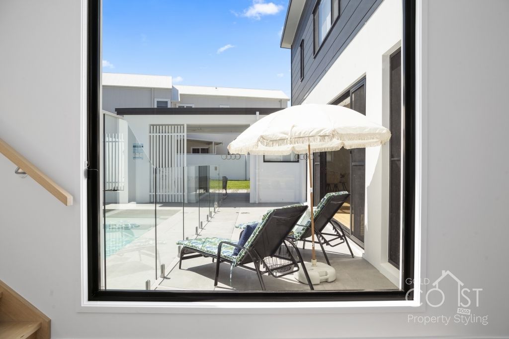A view of a swimming pool from a window in a house.