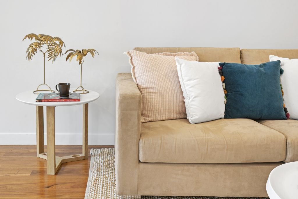 A living room with a couch , table , and pillows.