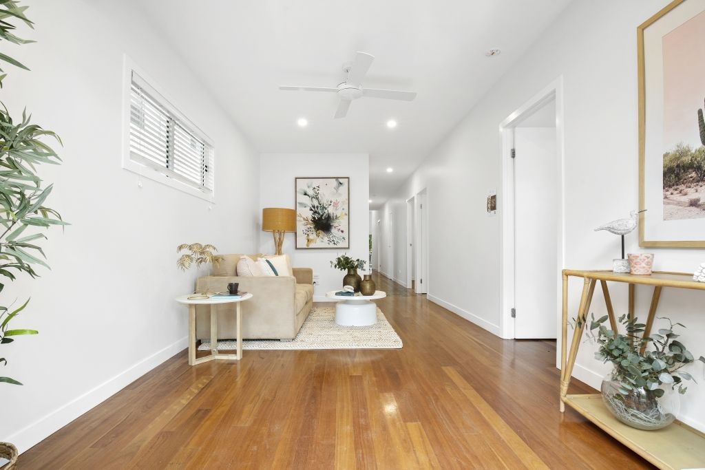 A living room with hardwood floors and a ceiling fan.
