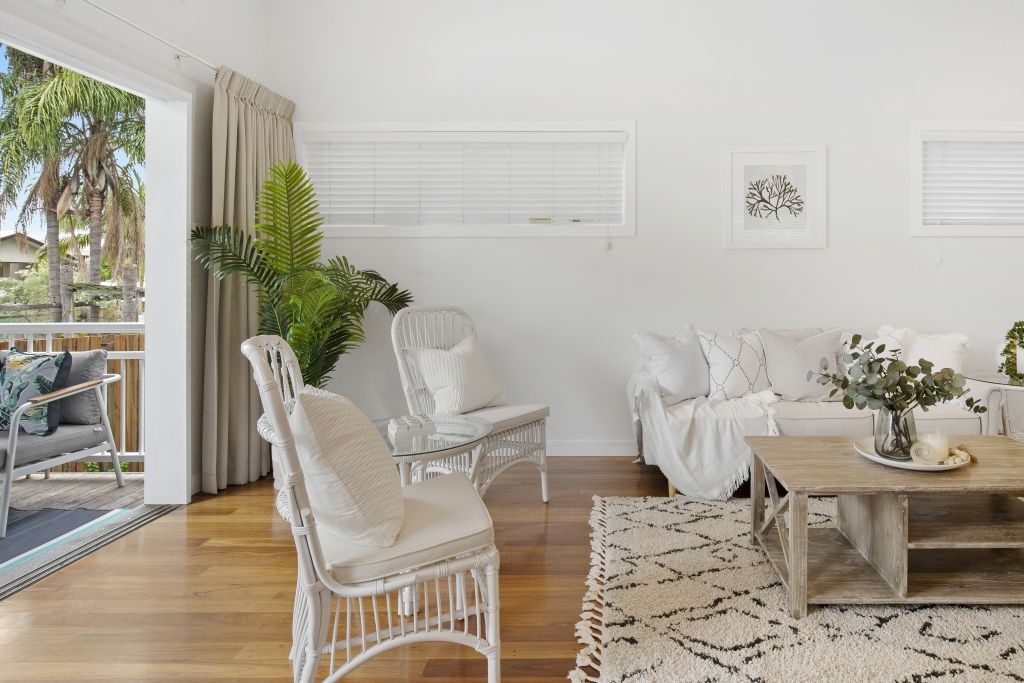 A living room with a couch , chairs , coffee table and rug.