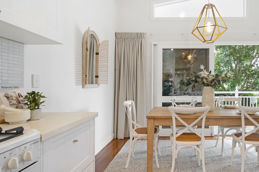 A kitchen and dining room with a wooden table and chairs.