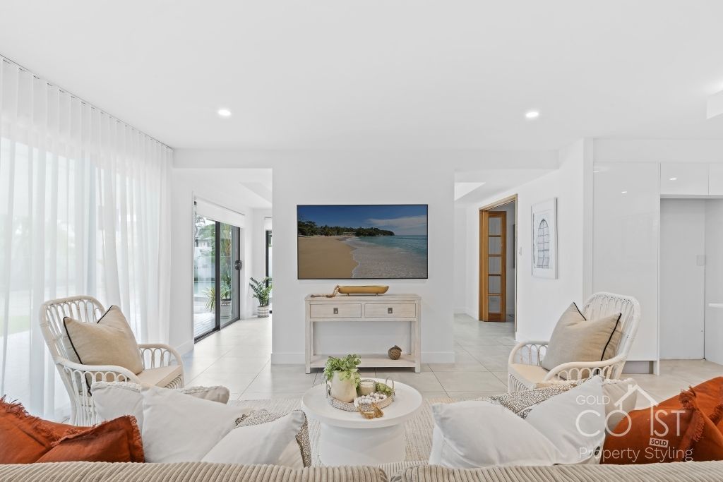 A living room with a couch , chairs , table and television.