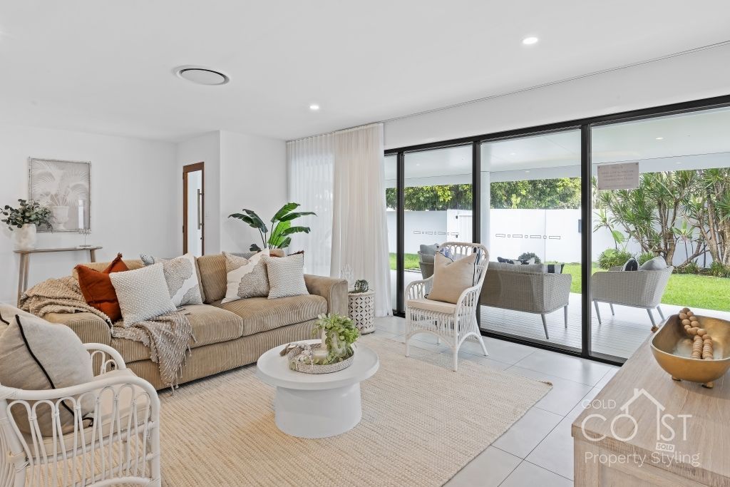 A living room with a couch , table , chairs and sliding glass doors.