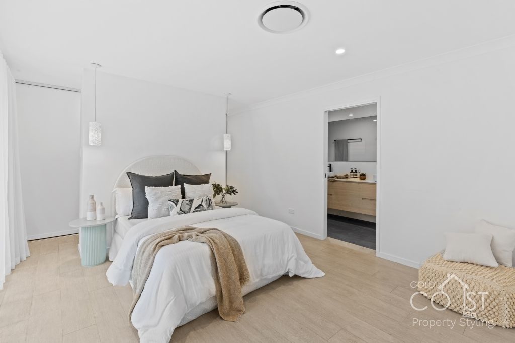 A bedroom with a large bed and a wooden floor.