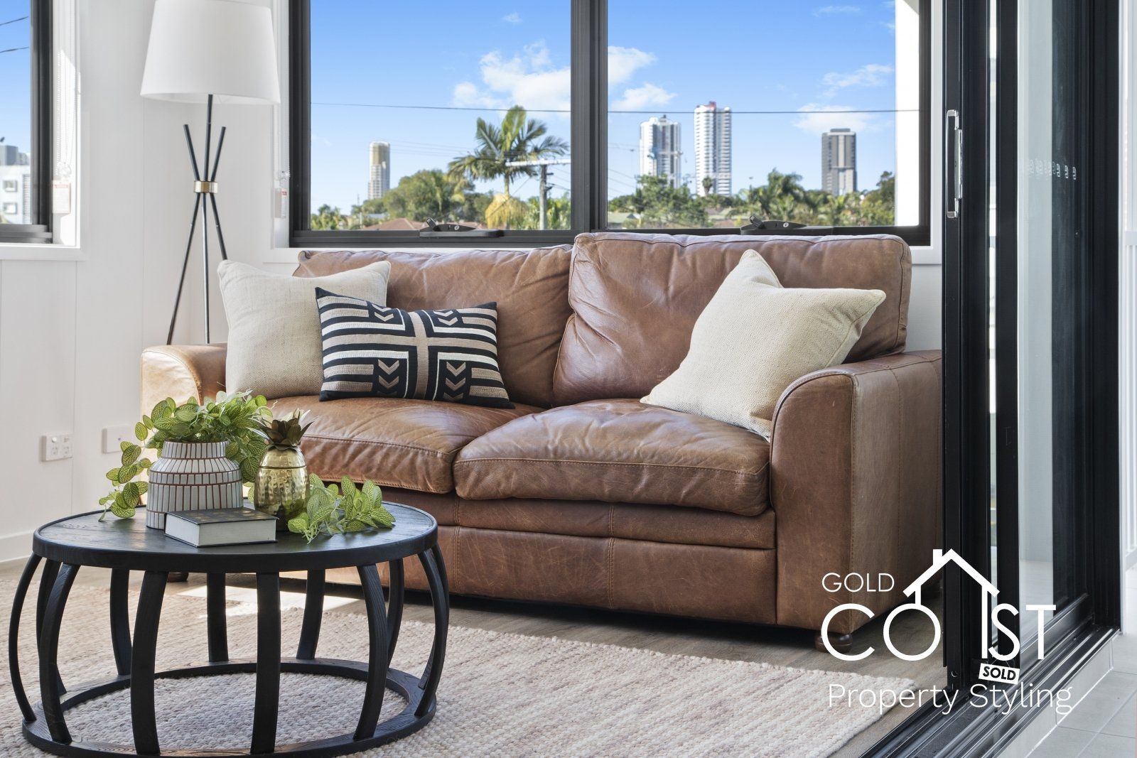 A living room with a brown leather couch and a black coffee table