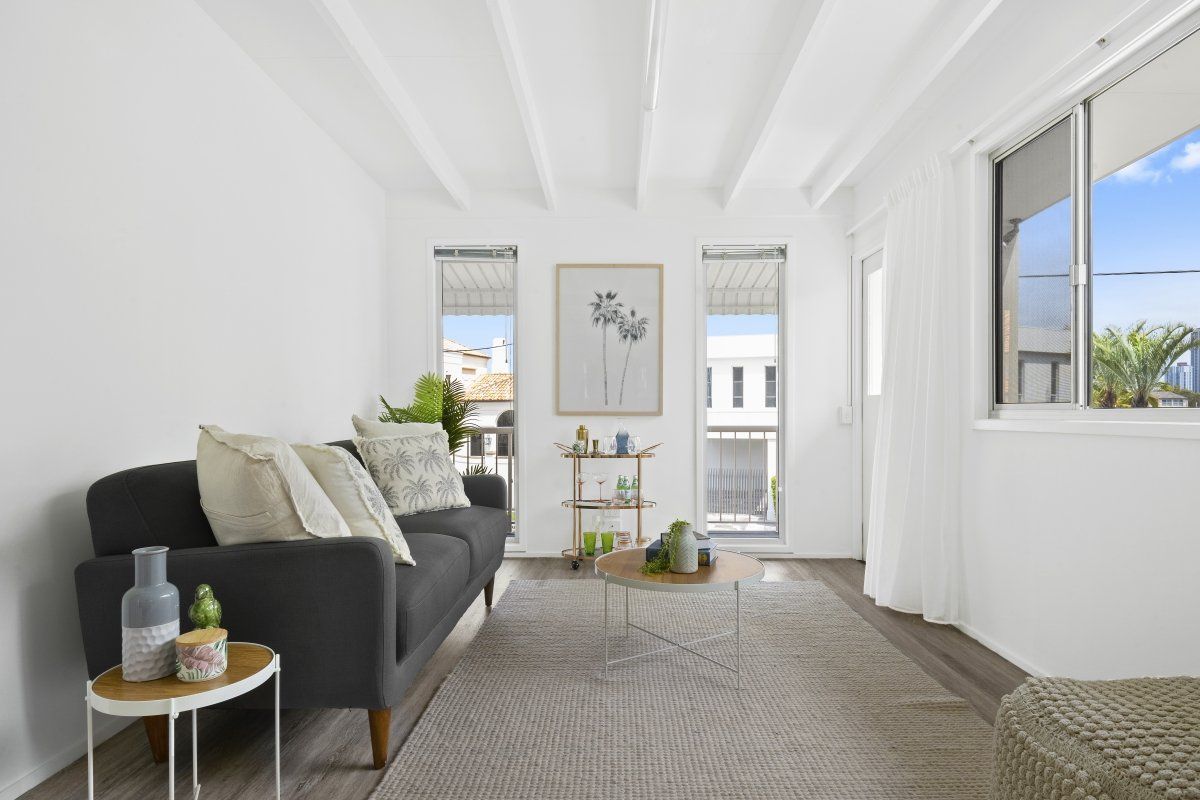 A living room with a couch , coffee table , and window.