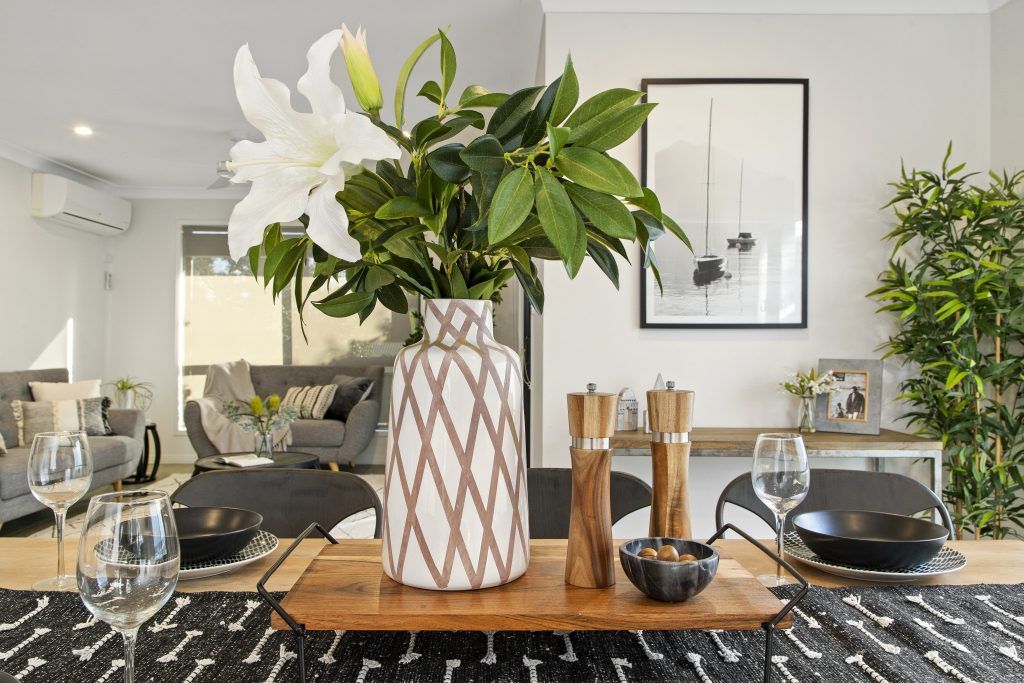 A vase of flowers is on a table in a living room.