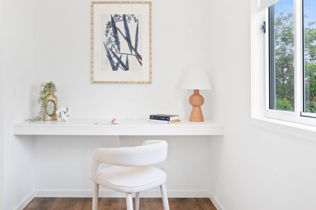 Minimal white home office with a desk, chair, wall art, and window light