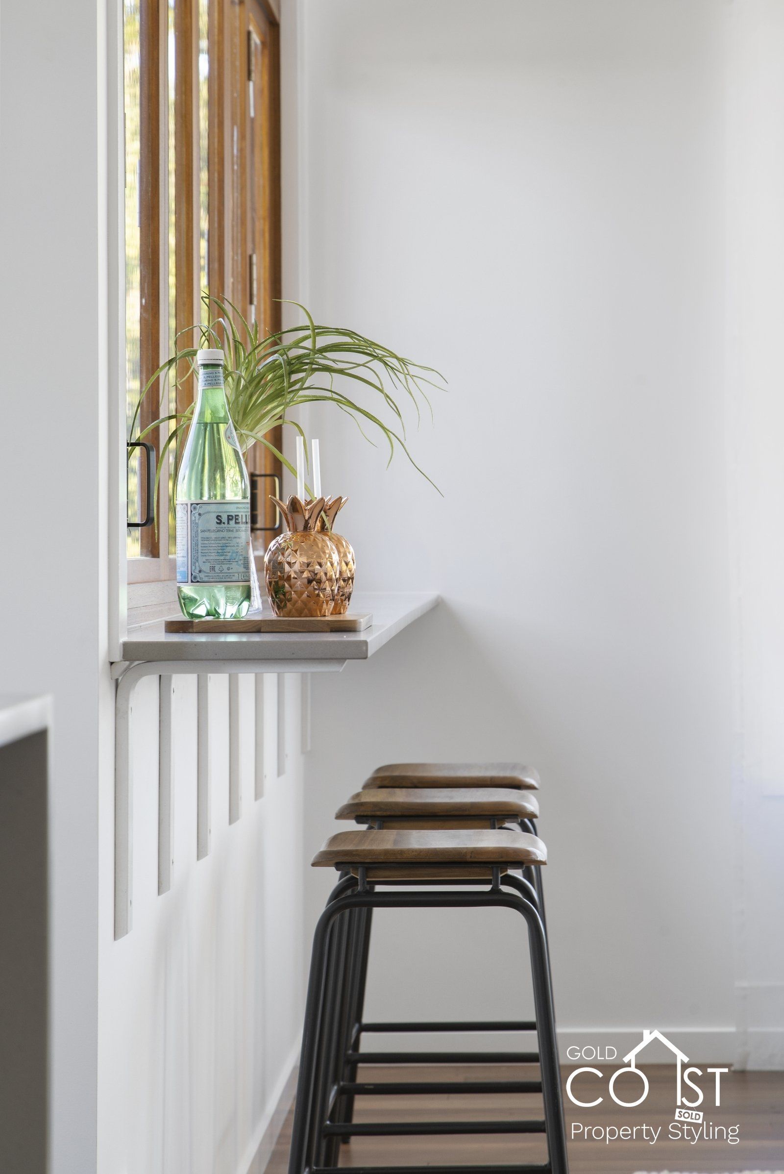 A row of bar stools sitting next to a window in a room.