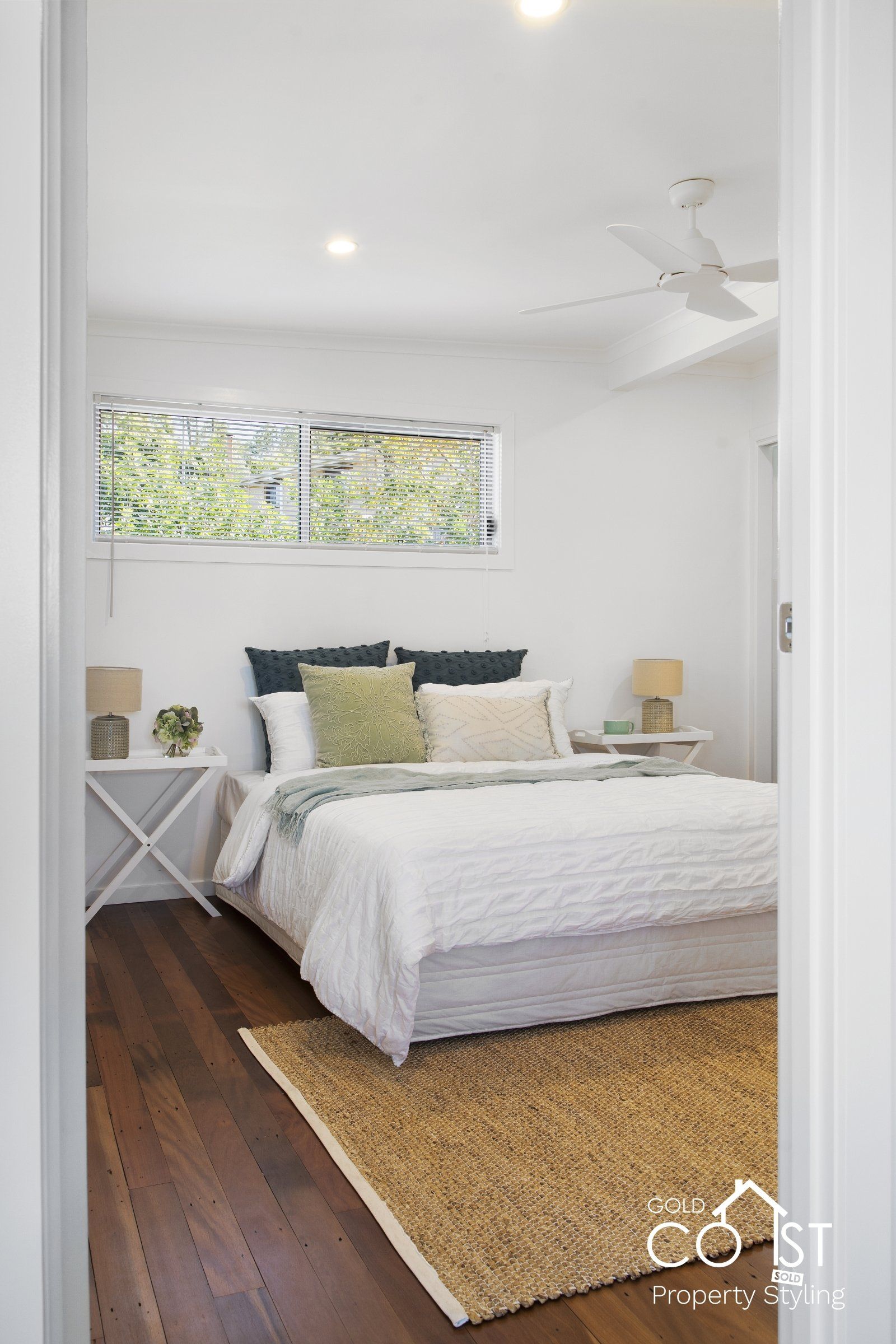 A bedroom with a bed , nightstand , rug and ceiling fan.
