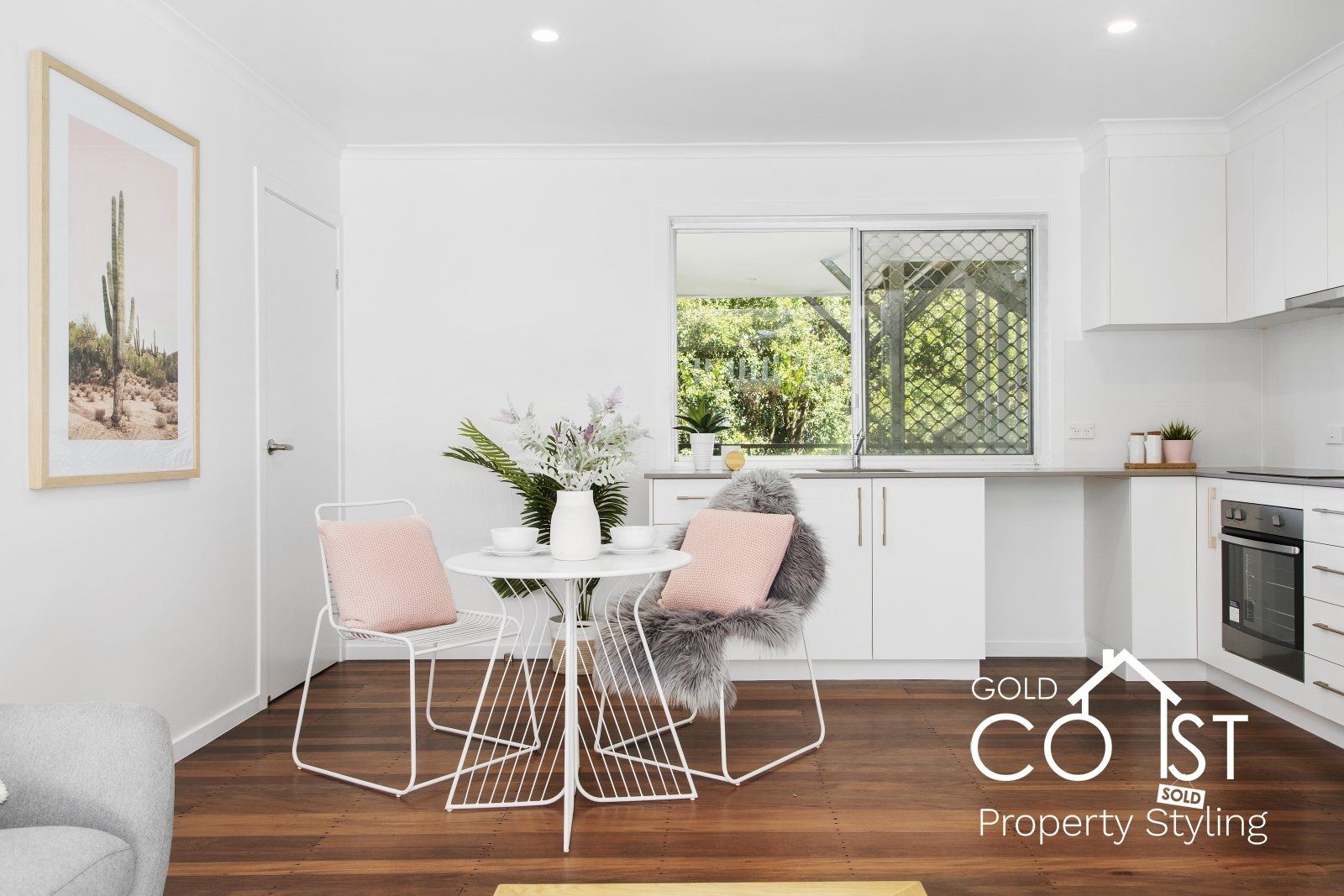 A living room with a table and chairs and a kitchen.