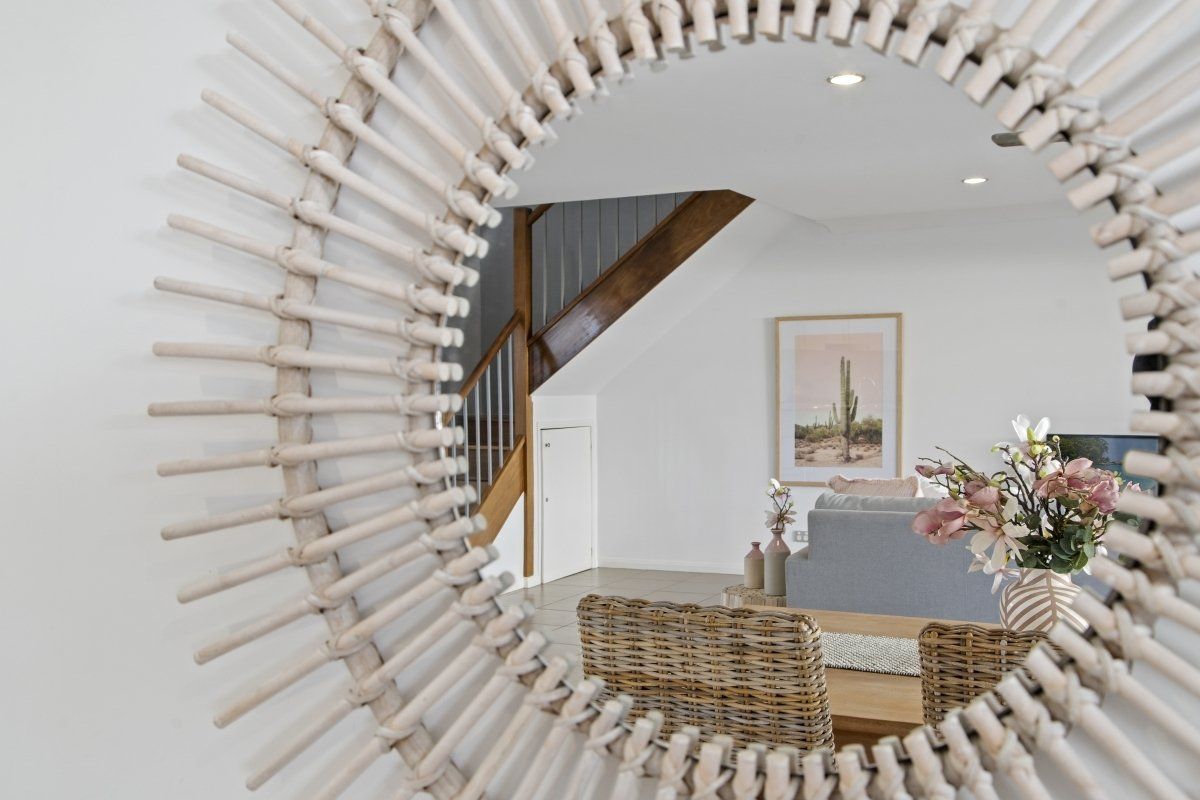 A round mirror is hanging on a wall in a living room.