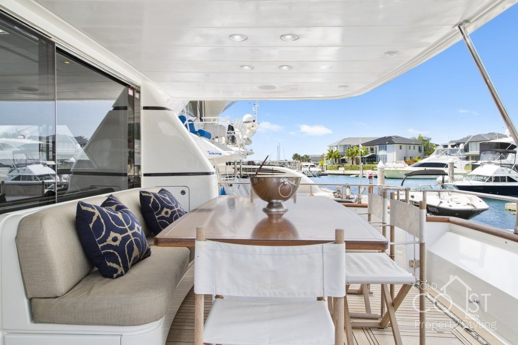 There is a table and chairs on the deck of a boat.