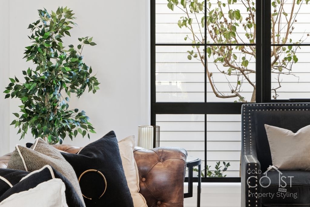 A living room with a couch and a chair and a window