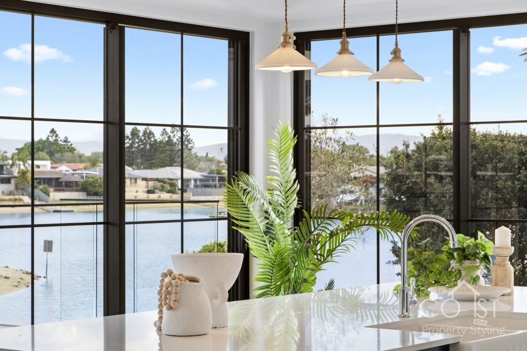 A kitchen with a large window overlooking a body of water.