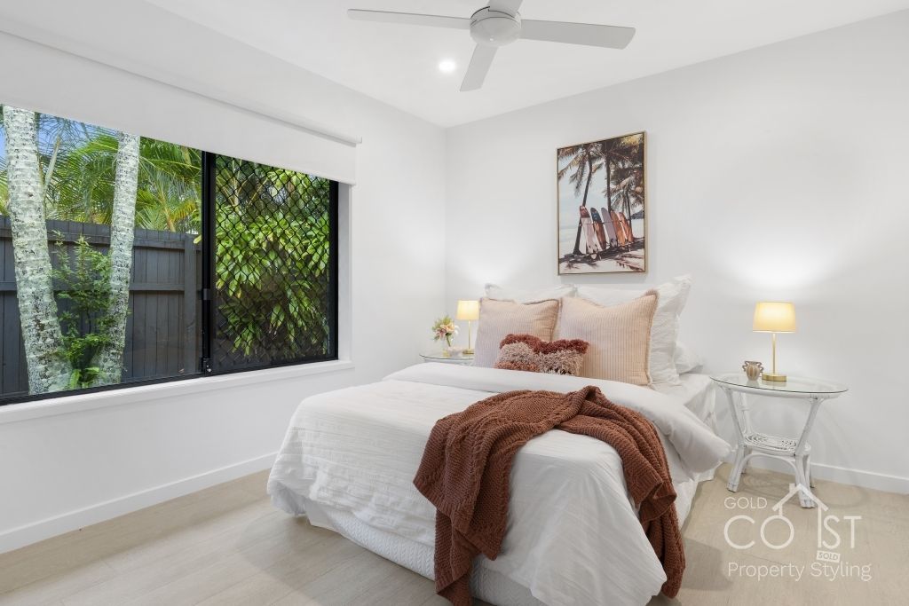 A bedroom with a bed and a ceiling fan