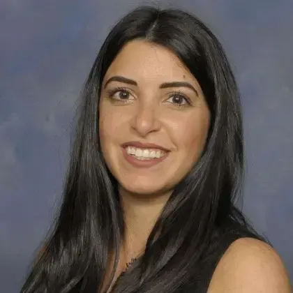 A woman with long black hair is smiling for the camera.