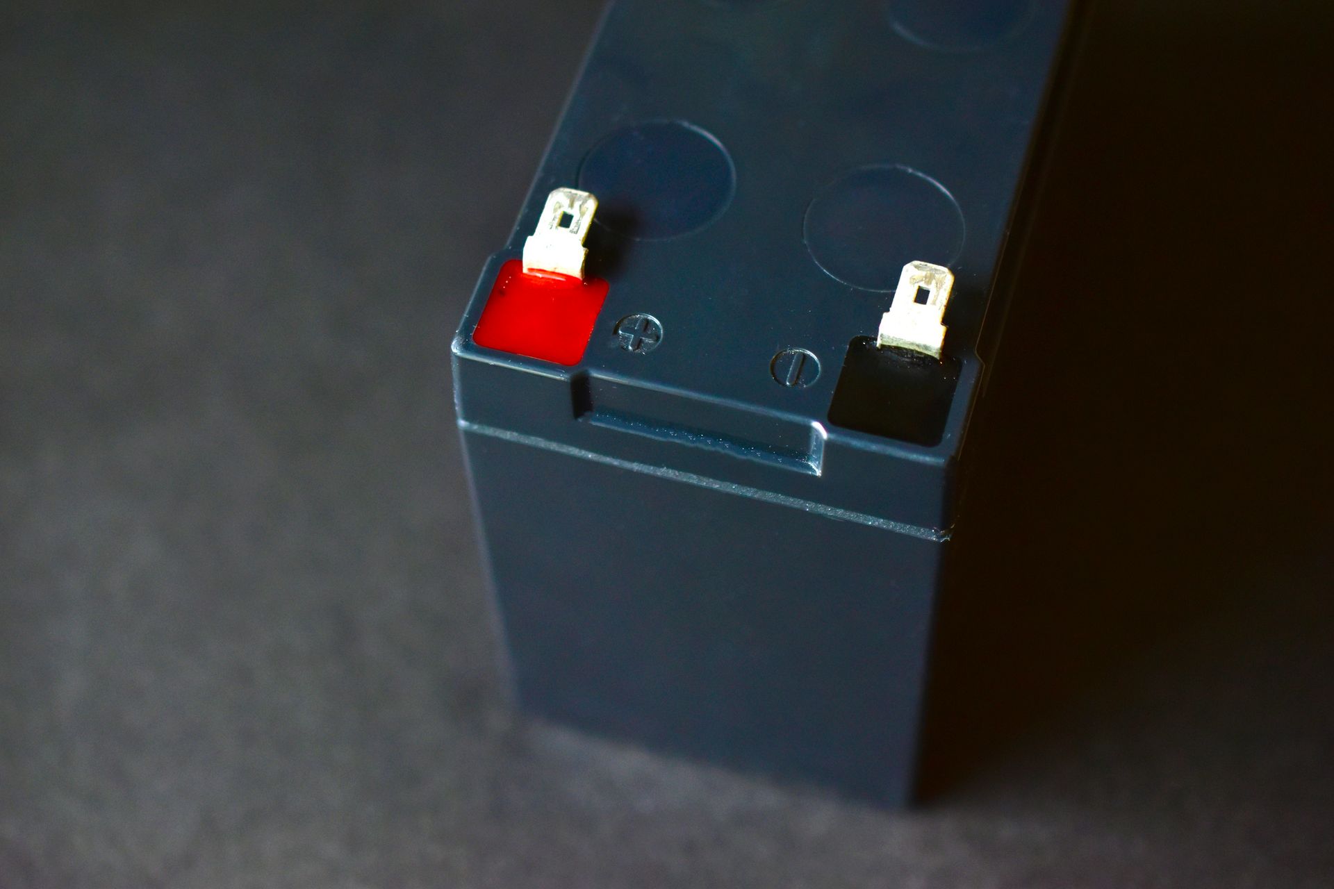 A close up of a battery on a black surface.
